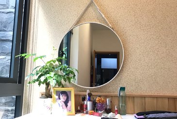 Hô biến không gian phòng ngủ với gương trang điểm treo tường dây da.